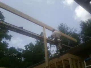 Carpenter setting a ridge beam over a new addition frame — Ice Dam Removal by Roofing Brothers in Rome City