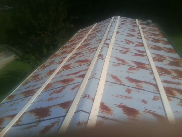 Rusted metal roof panels with new wood purlins before replacement — Storm Damage Roof Repair in Rome City by Roofing Brothers