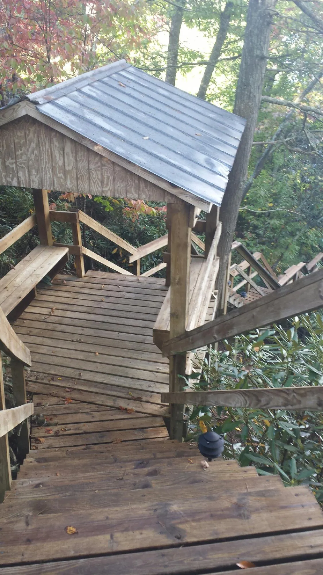 Metal roofed shelter over wooden steps on a wooded walkway — Skylight Repair & Installation work by our crew in Rome City